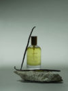 Huile relipidante et apaisante pour peaux sensibles mise en scène sur fond naturel avec de la vanille – soin apaisant et hydratant