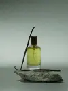 Huile relipidante et apaisante pour peaux sensibles mise en scène sur fond naturel avec de la vanille – soin apaisant et hydratant