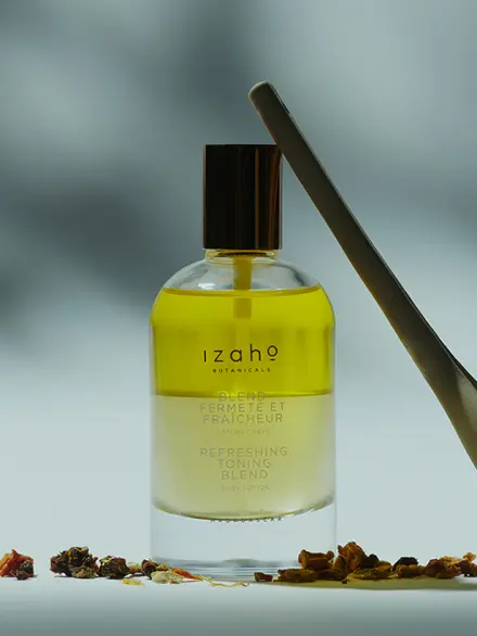 Huile biphasée fermeté et fraicheur pour peaux en manque de fermeté mise en scène sur fond naturel – soin tonifiant